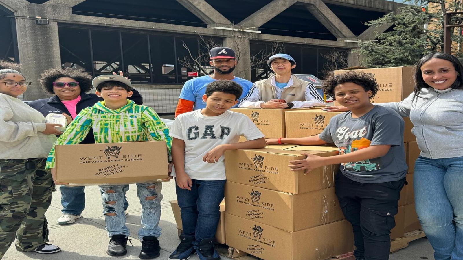 Children and adults posing for photos with boxes