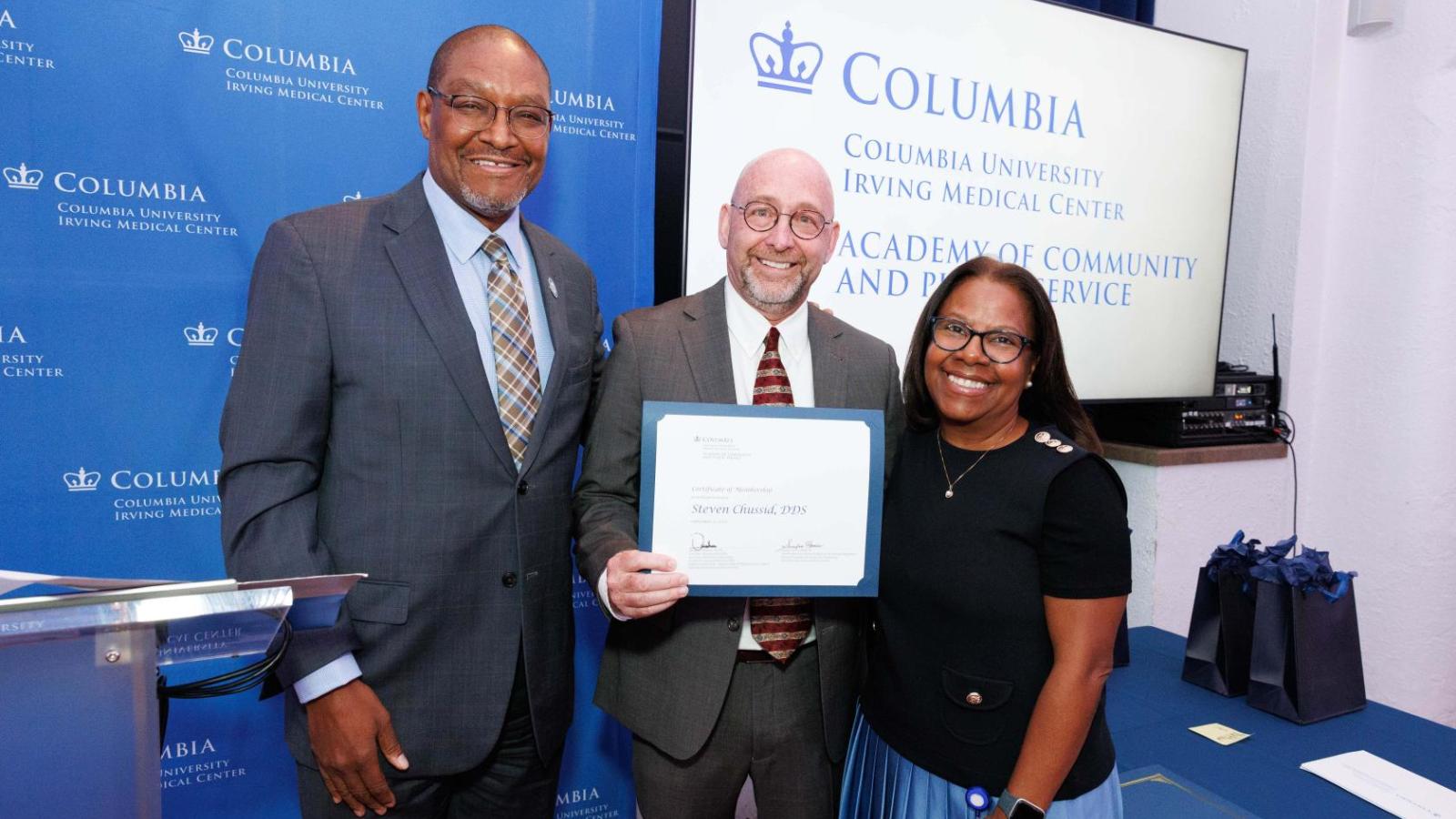 Three people smiling with Columbia University Irving Medical Center logo in the background