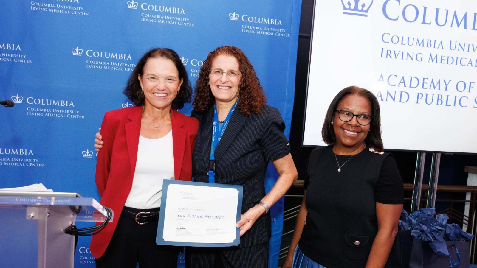 Three people smiling with Columbia University Irving Medical Center logo in the background